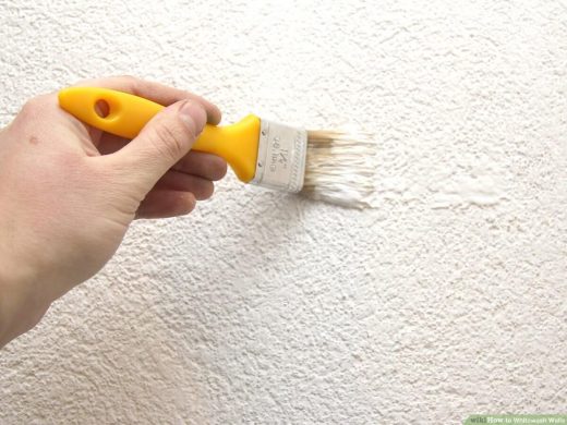 Whitewashing on a wall with a brush